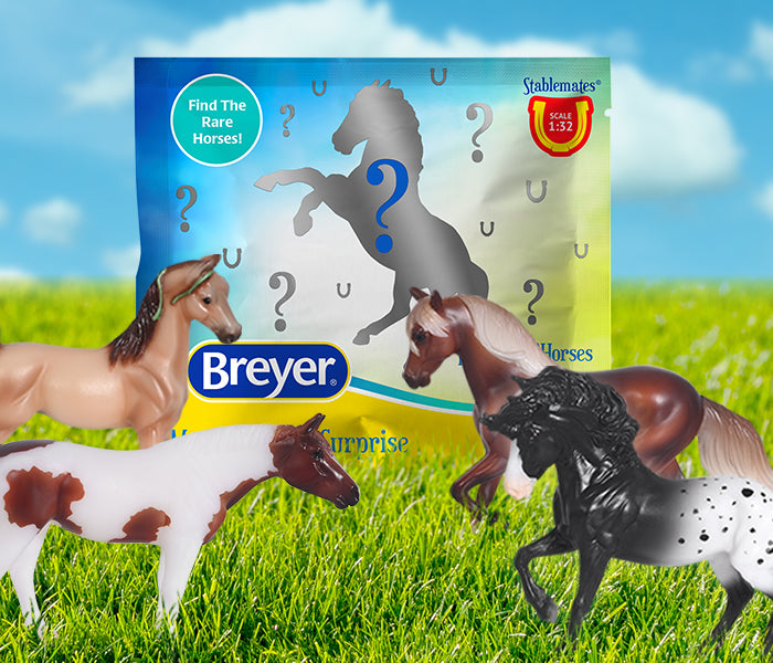 The packaging and models of a Breyer Surprise bag on a grassy setting