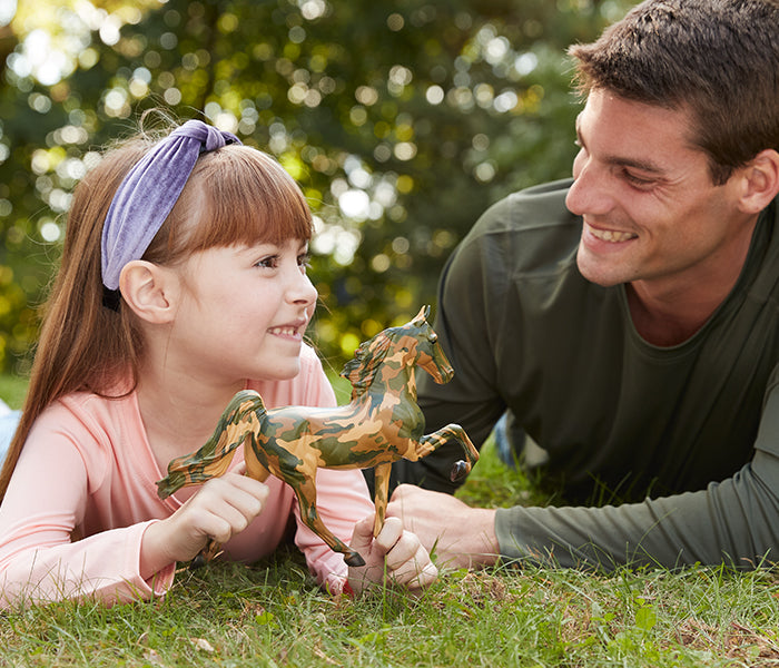 Honor Collection Banner - an adult and child in the lying in grass with an Honor model