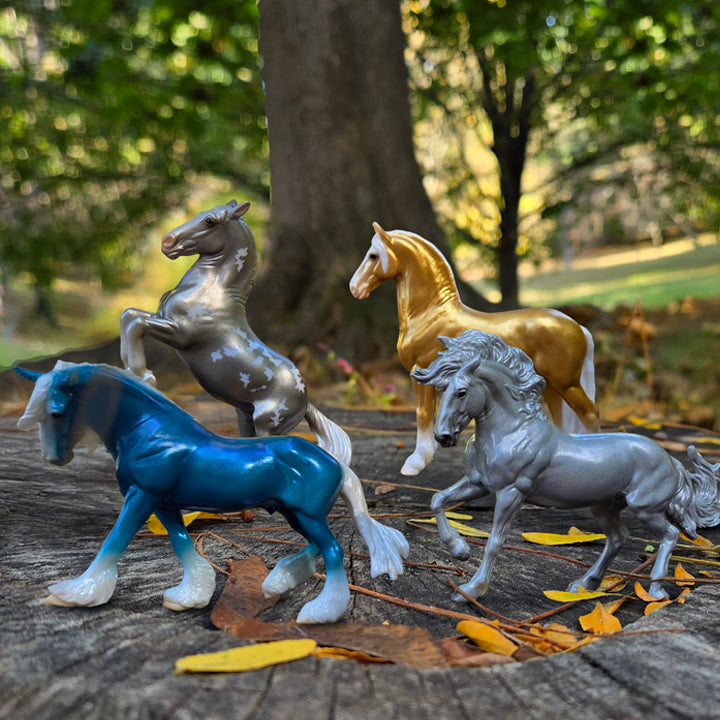 The 75th Anniversary Stablemates standing on a stump outside.