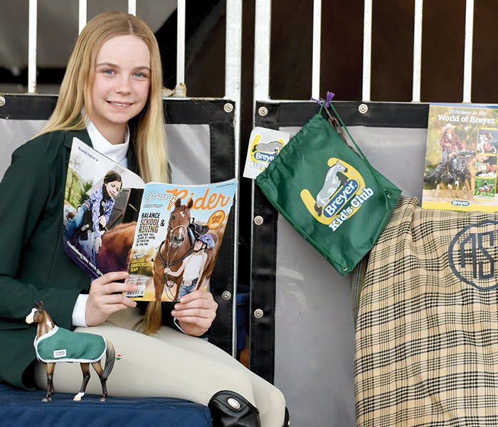 Join the Breyer Kids Club - a girl reading Young Rider Magazine with the Kids Club Model, bag and more