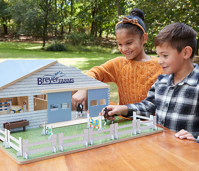 Home for the Holidays Mobile Banner - Two kids playing with a Breyer Barn