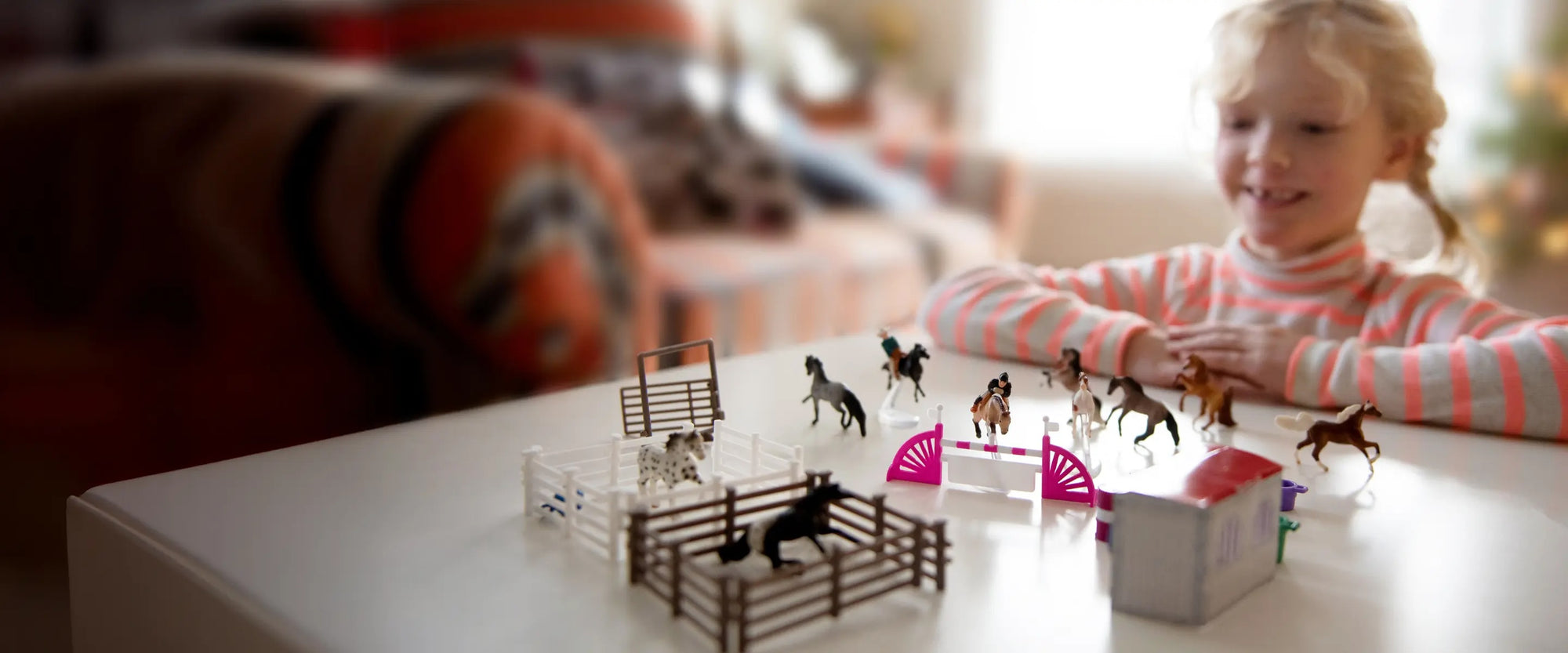 A girl playing with the Breyer Advent Calendar at a table