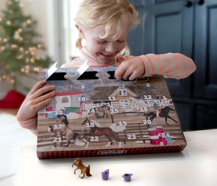 A girl opening the Breyer Advent Calendar at a table