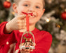 A child in red pajamas showing the Après Ski | Stirrup Ornament