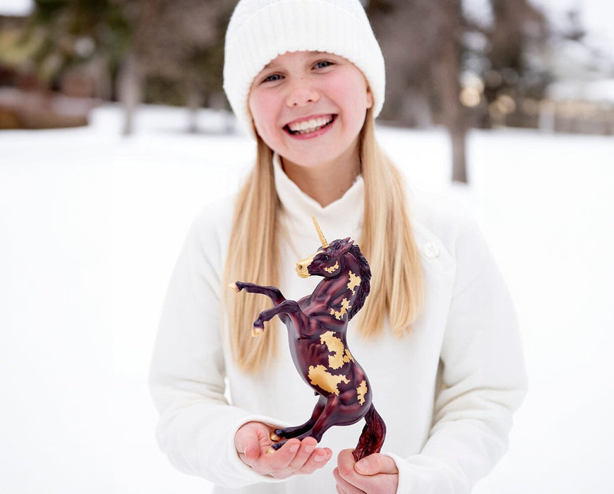 A child holding Auryn | Freedom Series Unicorn outside in the snow