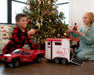 A girl and boy by the Christmas Tree playing with Benda, Austin and the Dually Truck and Trailer