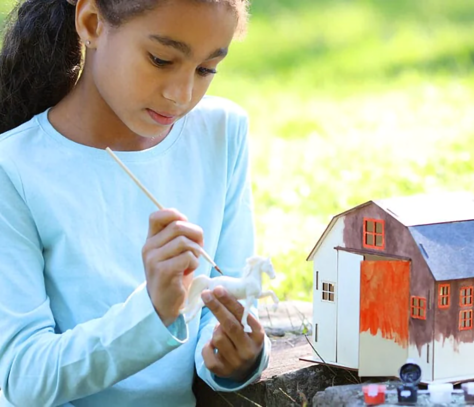 Girl painting Breyer Horse & Barn Paint & Play Set