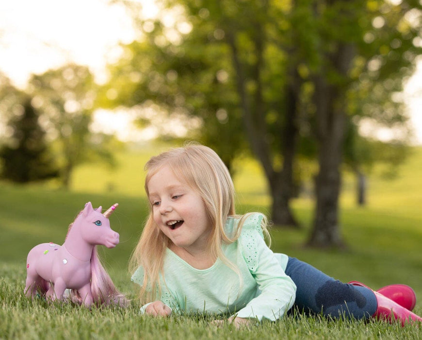 A girl lying in grass with Iris | Mane Beauty Styling Unicorn