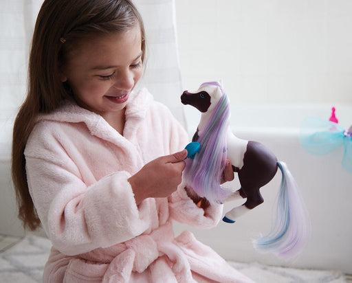 A girl brushing Marina Color Change Mer-Pony near a tub