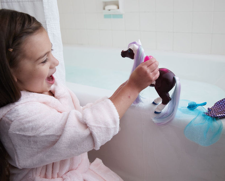 A girl playing with Marina Color Change Mer-Pony near on a bathtub