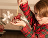 A child displaying the Scarlet | Unicorn Ornament