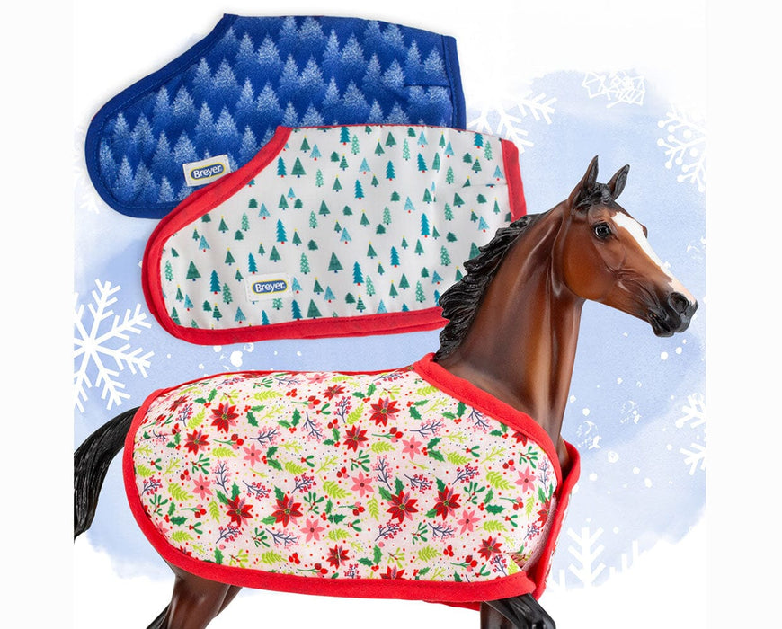 Traditional Holiday Horse Blanket; brown horse wearing poinsettia design with red trim; white blanket with green trees and red trim; blue blanket with trees and blue trim