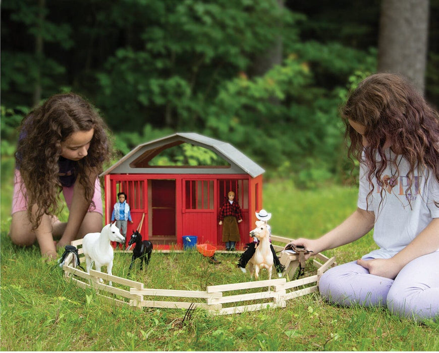 Two girls playing with the two stall barn, models and figures