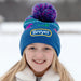 A girl wearing the Breyer Blue Pom-Pom Winter Hat