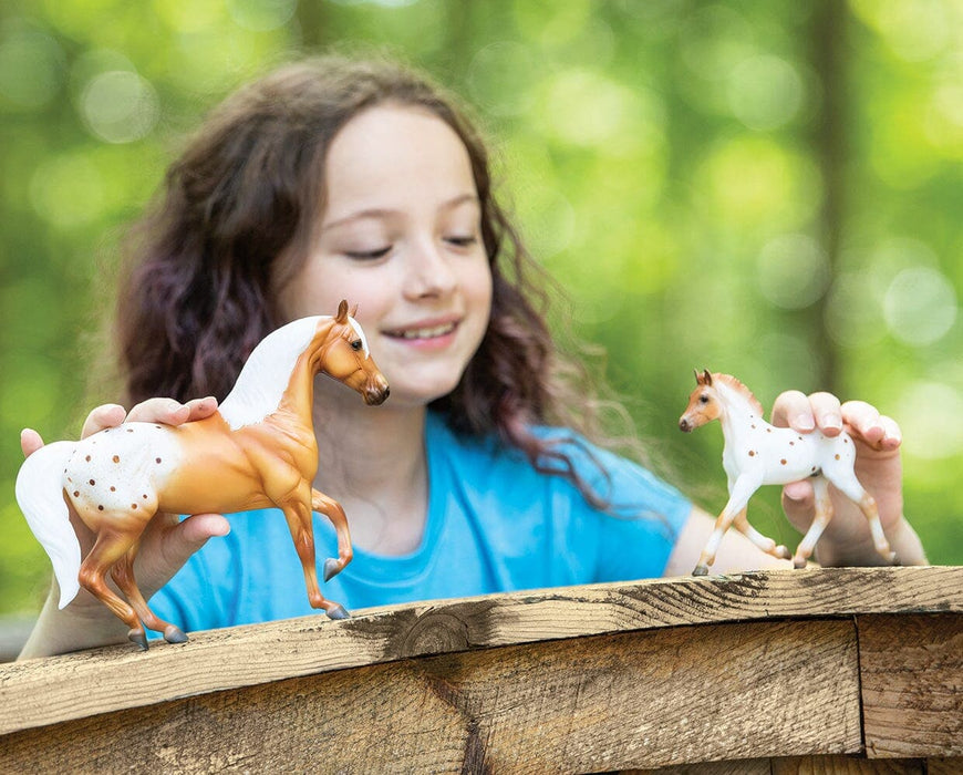 A girl playing with Effortless Grace Horse & Foal Set