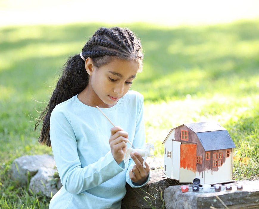 A girl painting the Horse & Barn Paint & Play