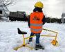 The Big Dig in the snow with a child wearing a Big Dig helmet and vest with a truck in the background